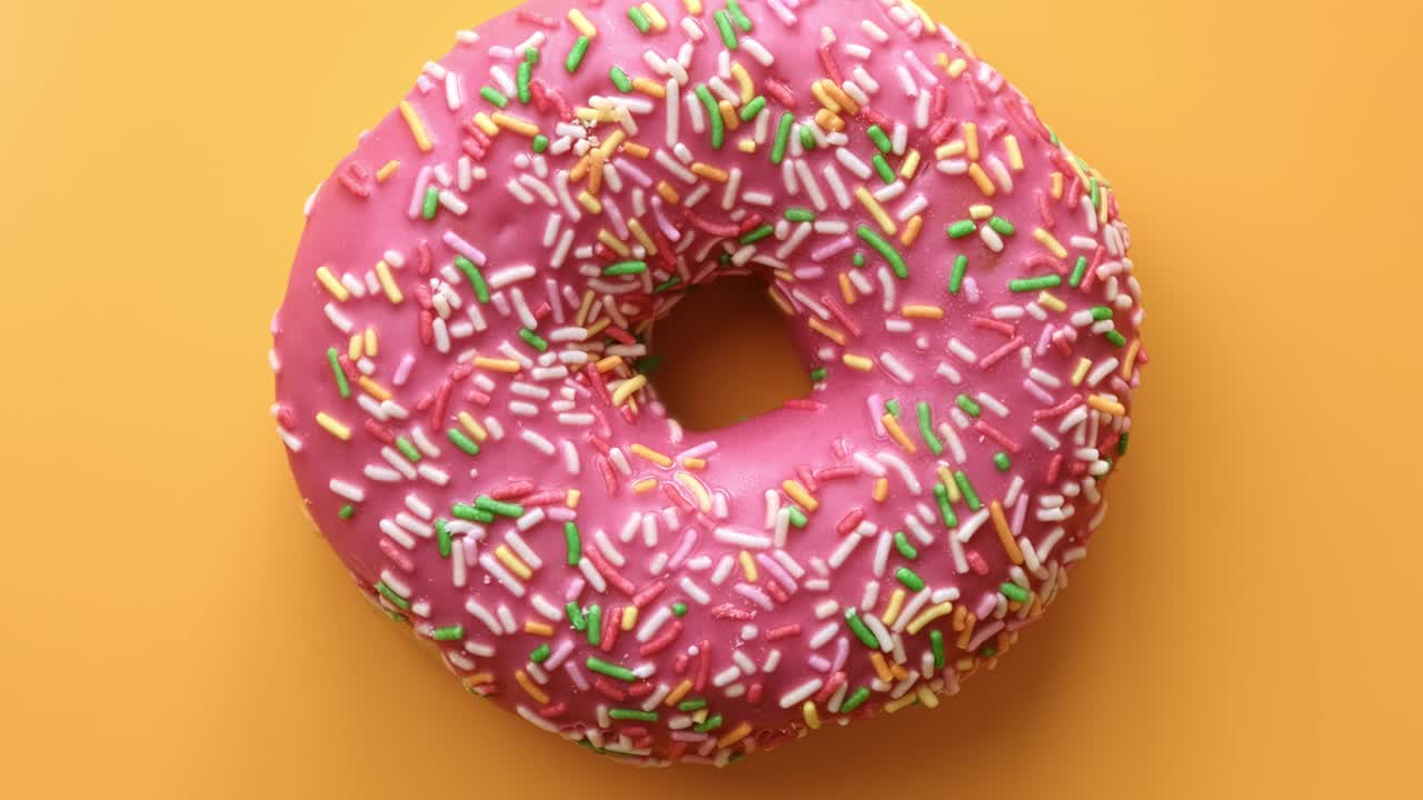 rosquilla multicolor con esmaltado rosado y topping de pastel aislado. disparo de primer plano en cámara roja 4k