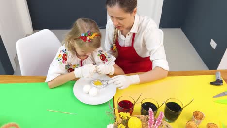 mother and daughter decorating easter eggs