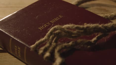 religious concept shot of old bible on wooden table with rope 1