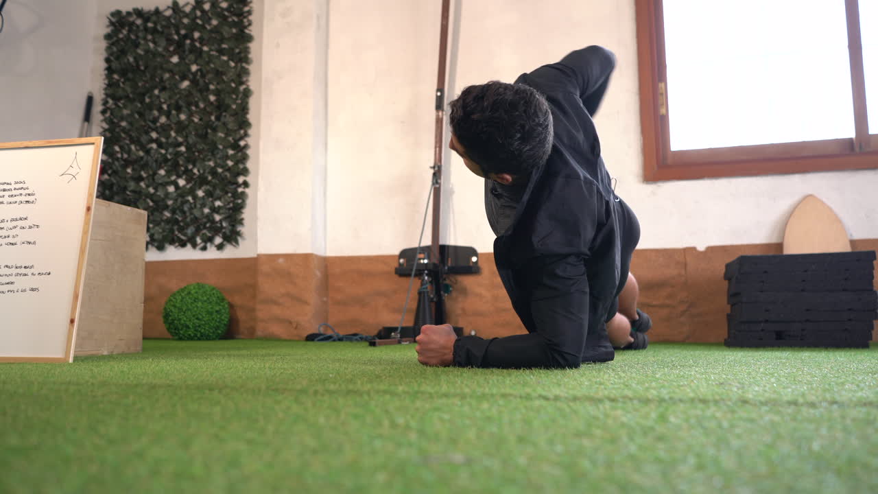 trainer performing oblique crunches changing from side to side on artificial grass