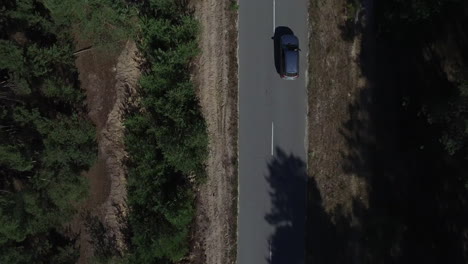 Copter-view-car-riding-on-road-at-forest.-Aerial-view-drone-flying-over-road