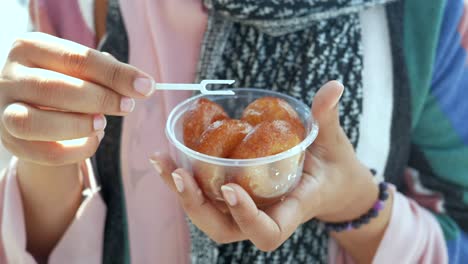 woman holding a plate of gulab jamun