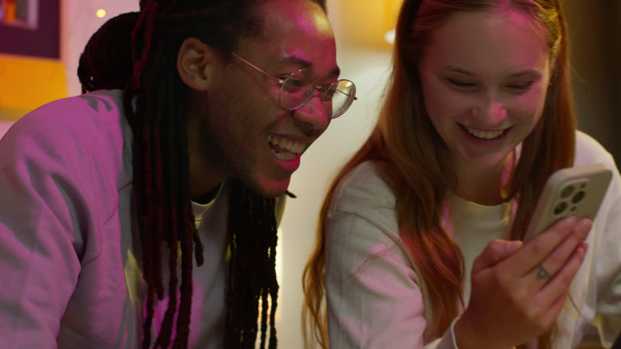 una pareja feliz mirando un teléfono juntos