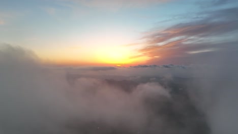 flying towards sunrise over green valley with clouds