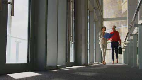 Caucasian-businesswomen-discussing-over-documents-in-the-corridor-4k