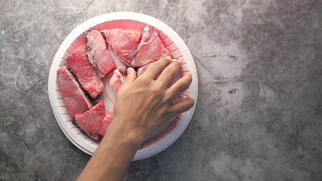 preparing raw fish steaks for cooking