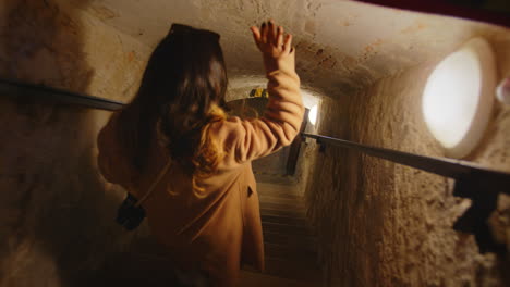 young woman entering the catacombs of a church