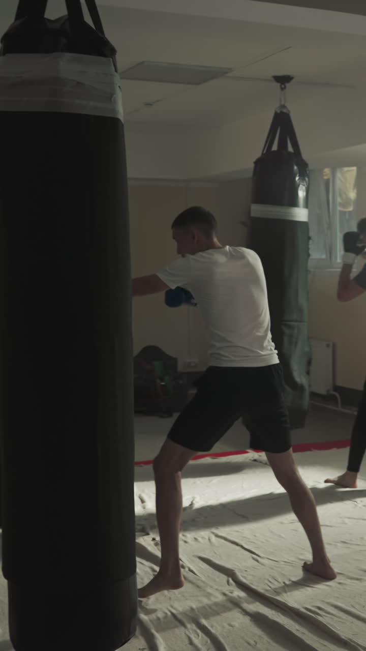los luchadores de taekwondo entrenan con equipos deportivos en el gimnasio. los deportistas profesionales golpean y patean en equipo haciendo ejercicio en cámara lenta del club. el entrenamiento de los atletas