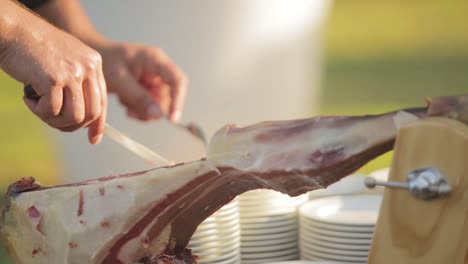 person cutting spanish ham