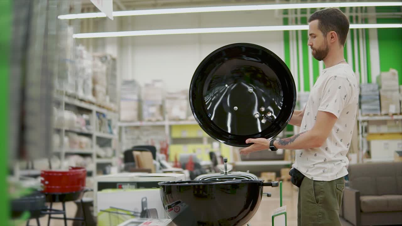 상점 에서 검은색 그릴 을 검사 하는 사람