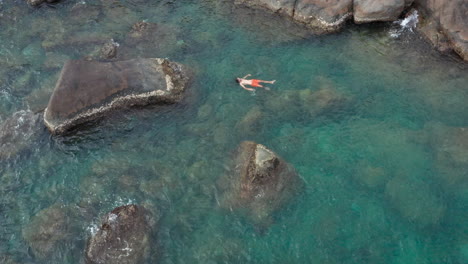 Aerial---Man-Floating-on-back-on-Surface-of-Turquoise-Ocean-Water