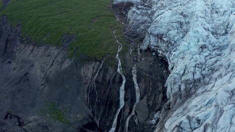 agua derretida del glaciar que fluye desde el acantilado de la montaña, antena