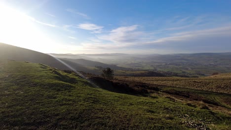 distant misty layers of panoramic rural mountain valley countryside at sunrise timelapse