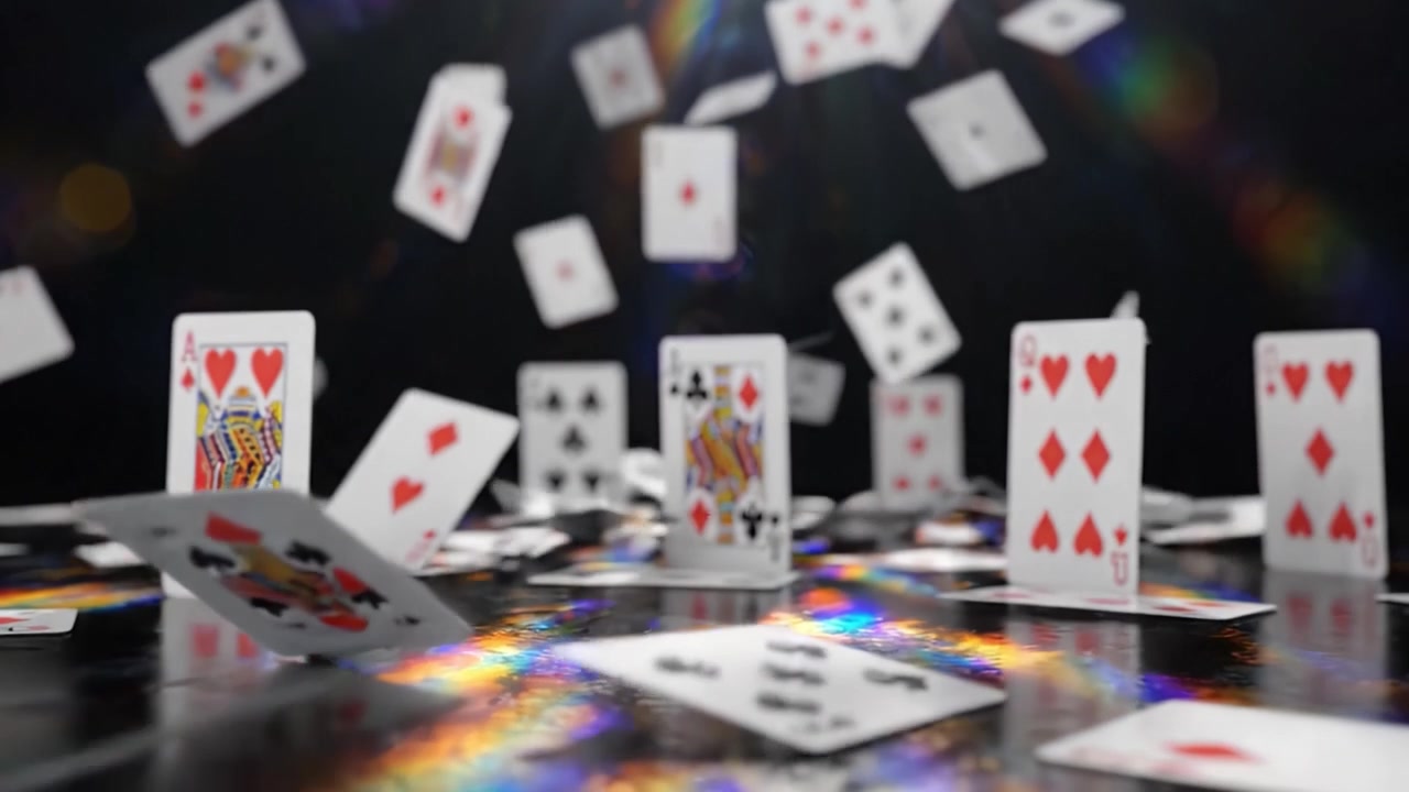 Una scena accattivante di carte da gioco che cadono dall'alto, creando un bellissimo motivo su uno sfondo scuro illuminato da una luce radiosa.