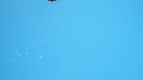 una sola morera volando por el aire con gotas de agua, girando