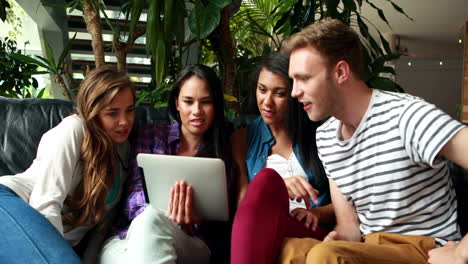 happy friends sitting and using laptop