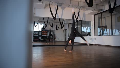 woman practicing acrobatic yoga in a studio