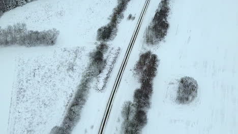 Top-down-soothing-aerial-winter-road-curve-view-from-left-to-right-with-TILT-UP