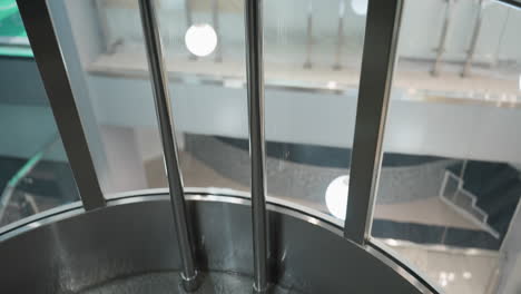 a beautiful view from an elevator, capturing the surroundings through the glass walls. the image showcases the modern architectural design and ambient lighting of the building