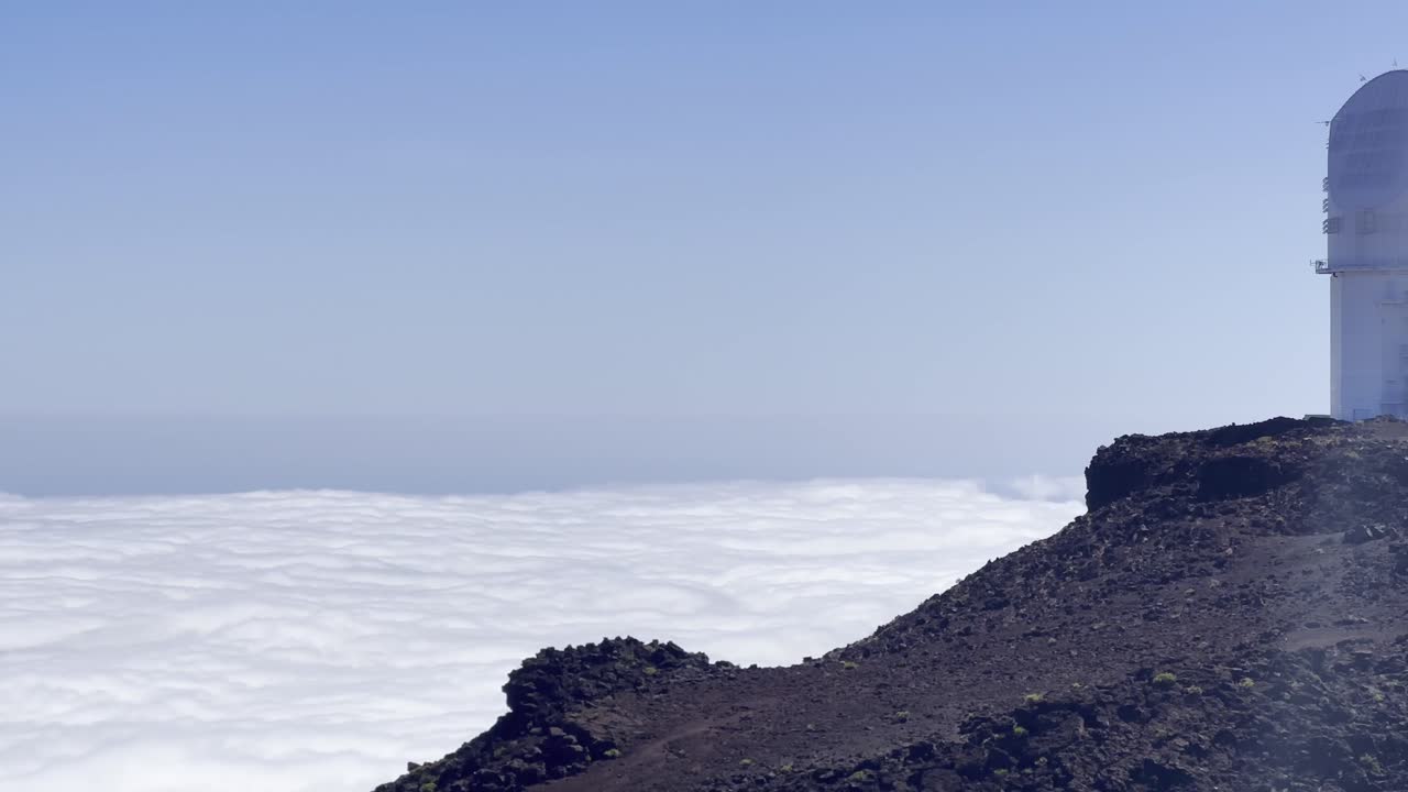 Cinematic panning shot of the Haleakala Observatory above the clouds at the summit of Haleakala in Maui, Hawai'i