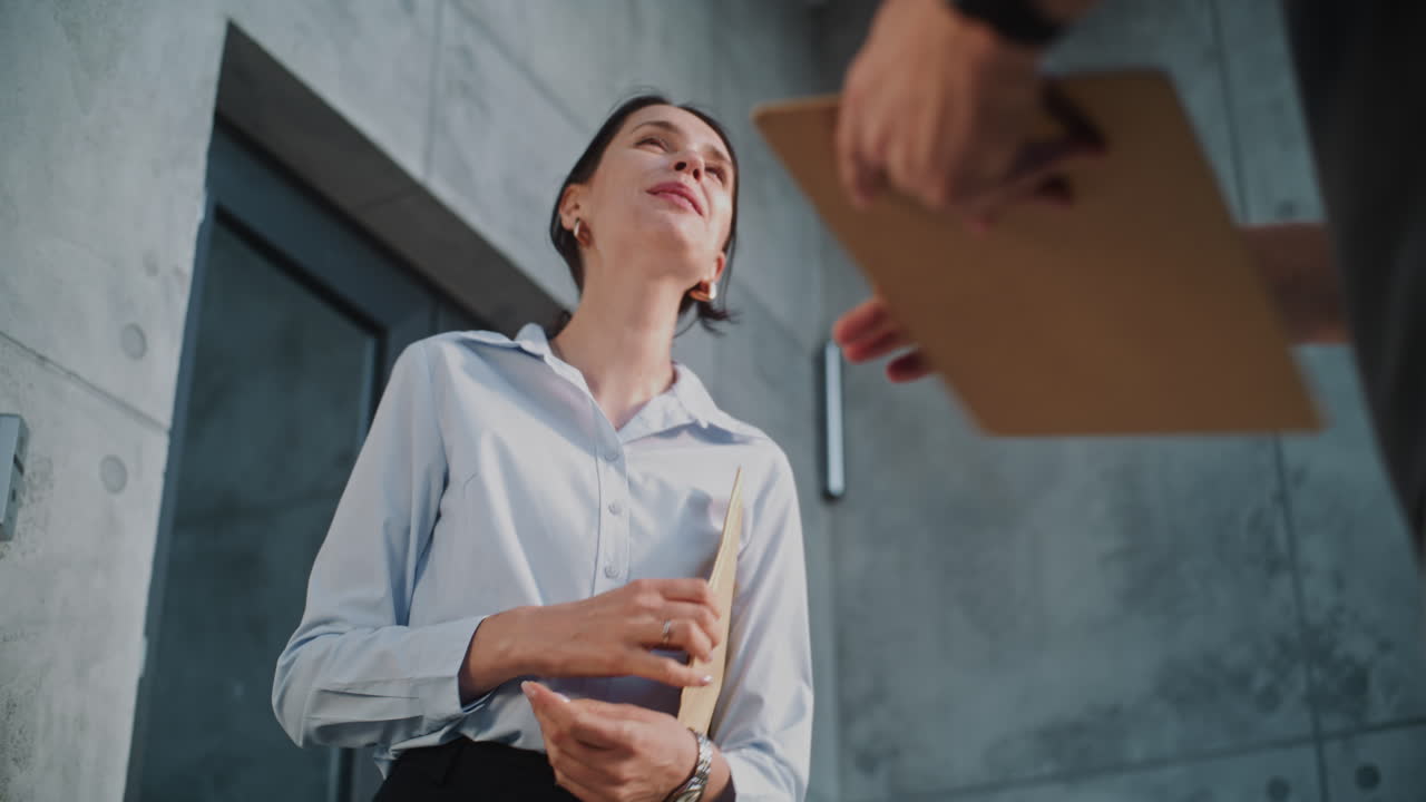 Woman receives and signs for a package delivery from a courier