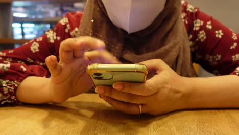 woman using a smartphone in a cafe