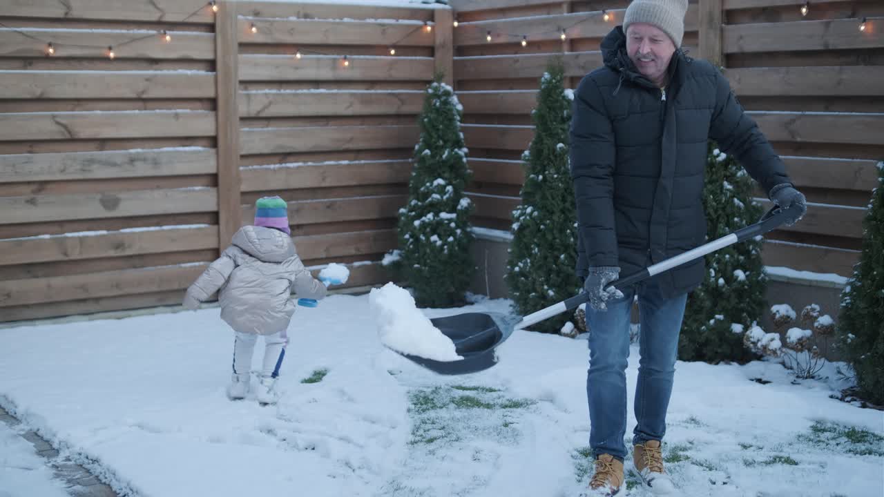 할아버지와 손녀가 눈 속에서 재미를 느끼고 있습니다.