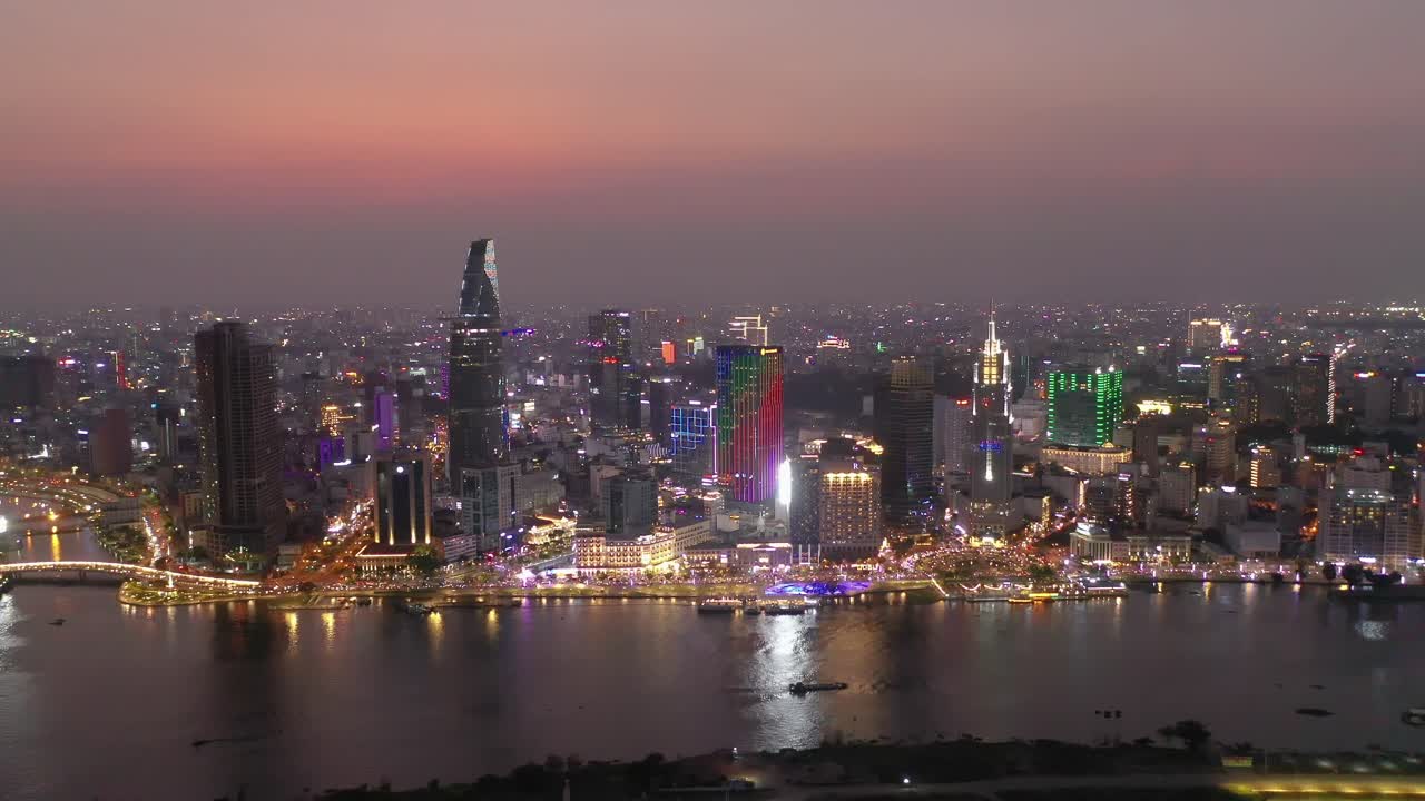 Yoğun bir akşamda, Ho Chi Minh Şehri, Vietnam'ın ikonik silüeti ve Saygon nehri kıyısı havadan panoraması; tüm önemli binaların güzel renkli gökyüzüne karşı aydınlatıldığı anlar.