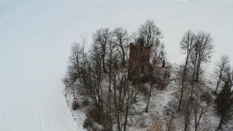 aerial circle shot above old abandoned church bell tower remains during winter