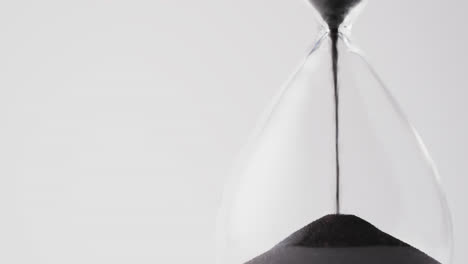 Video-of-hourglass-with-sand-pouring,-copy-space-on-white-background