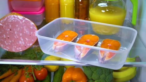 raw salmon steak in the open refrigerator