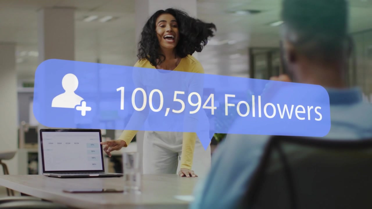Woman leaning over laptop tapping screen causing blue follower badge growing to 902k to show growth