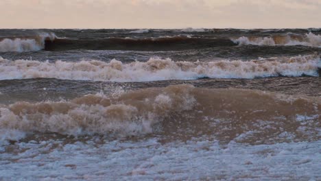 sea storm with big waves at sunset