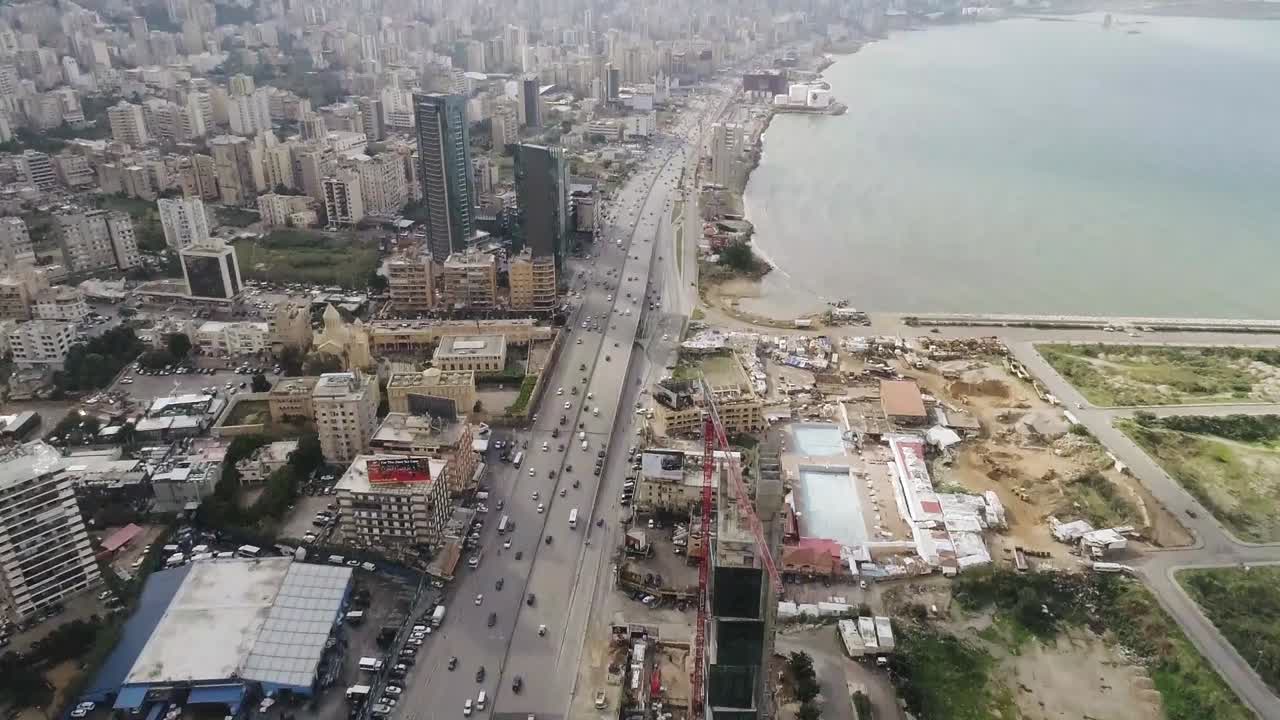 Aerial drone view of highway - free way busy city during a rush hour. Aerial view of the vehicular intersection, smooth traffic. Tilting up.
