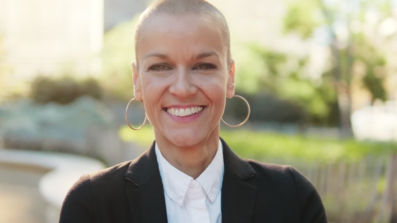 Donna professionista con la testa rasata sorride fiduciosa all'aperto