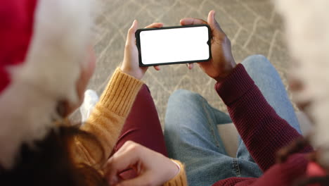 Happy-diverse-couple-using-smartphone-with-copy-space-at-chistmas-time,-slow-motion