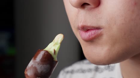 close-up of a man eating and enjoying a chocolate ice cream