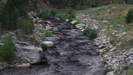 Un-Deslizamiento-De-Lodo-Tiñe-De-Negro-El-Río-Big-Thompson-Después-De-Una-Tormenta-De-Verano-Cerca-De-Glen-Haven,-Colorado,-15-De-Julio-De-2022