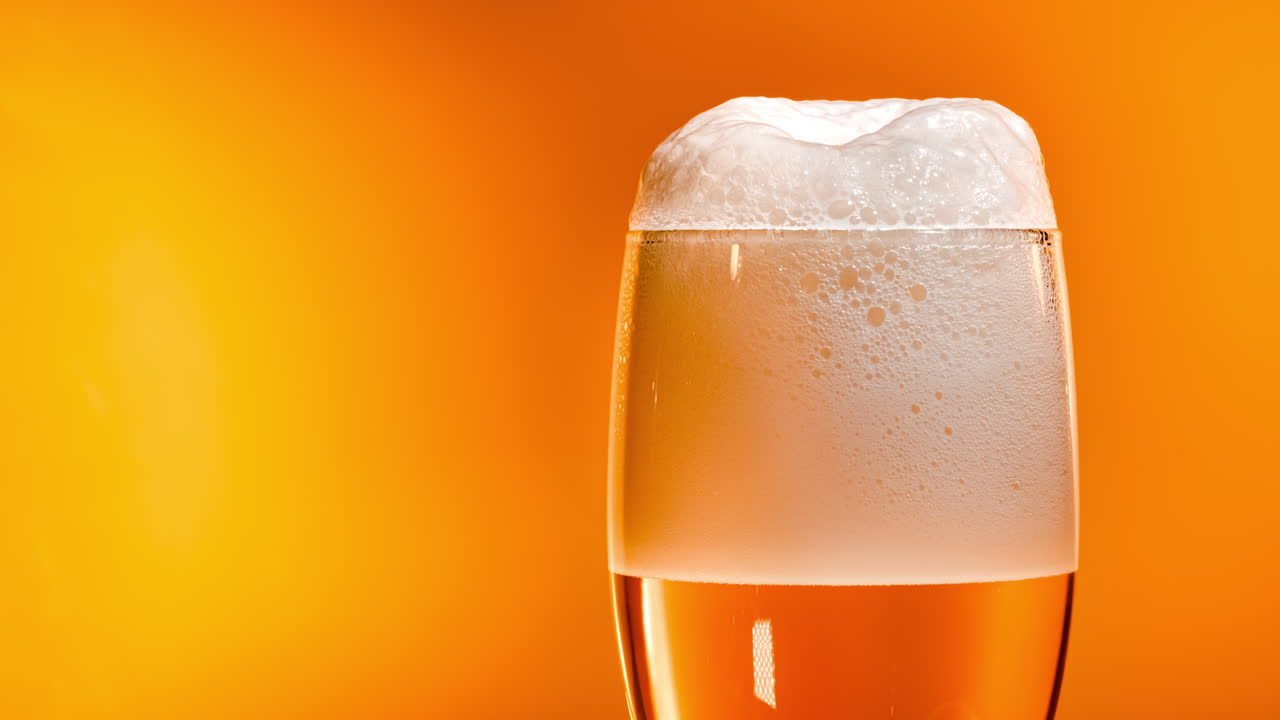 la cerveza lager se asienta en el vaso con una tapa blanca de espuma