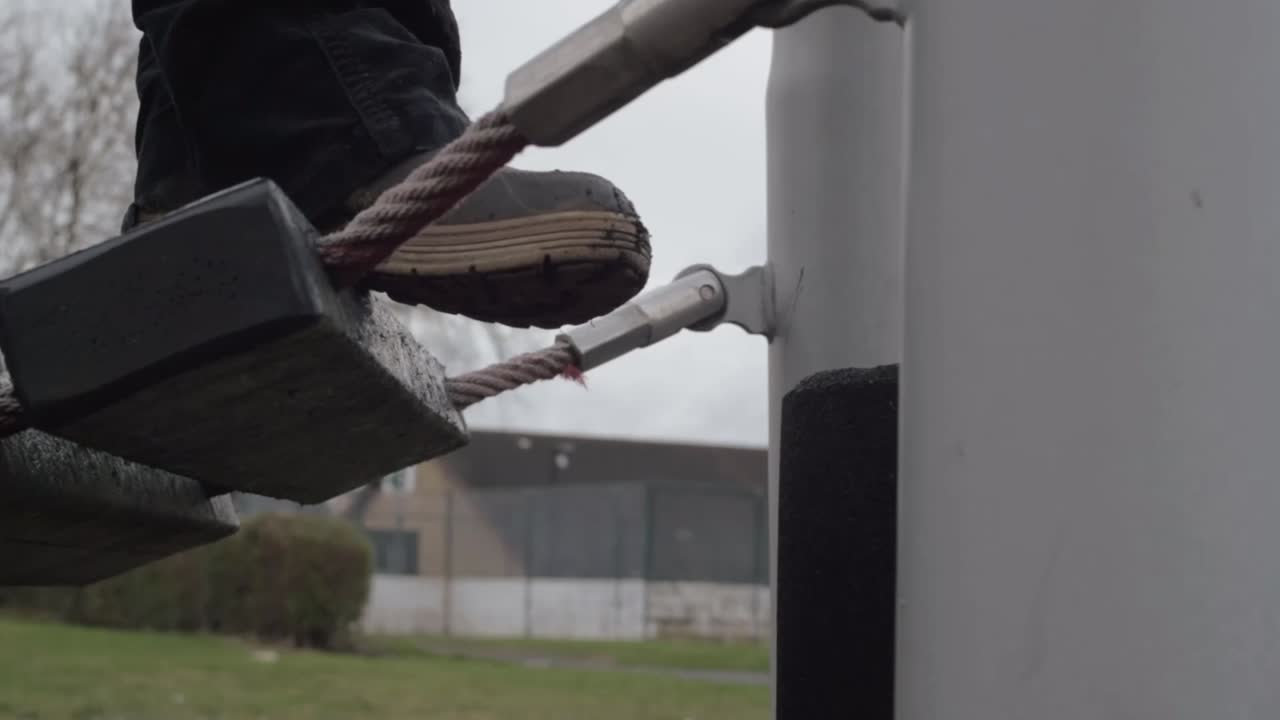 Feet balancing on rope bridge in park
