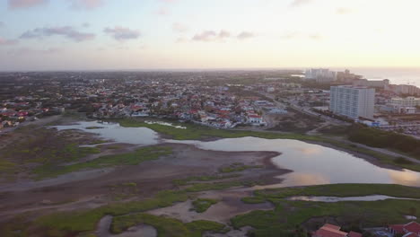 Ein-Natürlicher-See,-Der-Den-Himmel-Reflektiert,-Sitzt-Vor-Einem-Nachbarschaft-In-Aruba