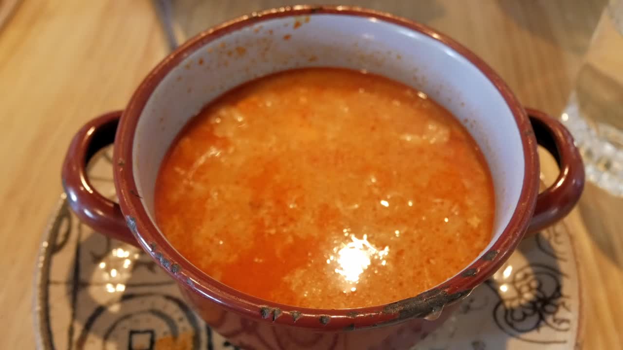 A bowl of Sopa Castellana, a traditional Spanish Castilian soup, served hot with a piece of bread