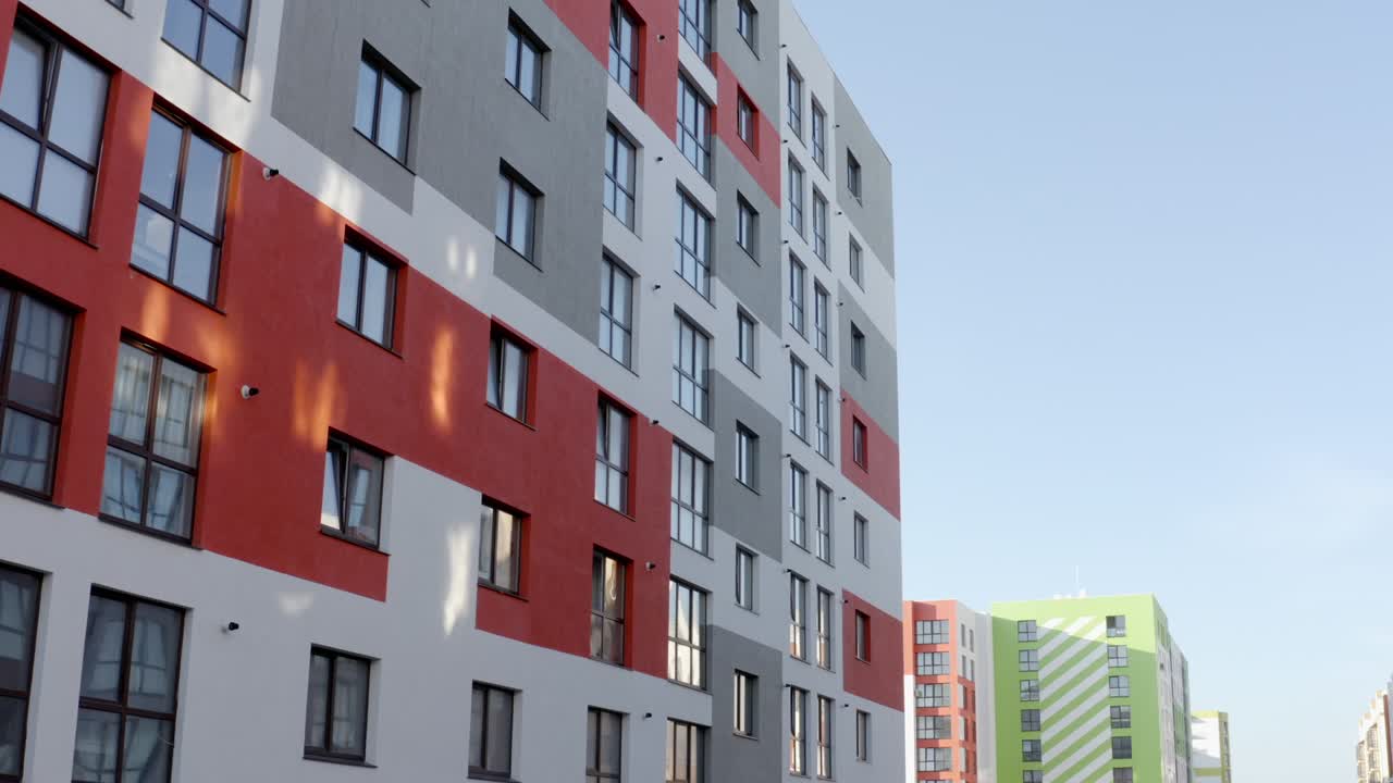 vista de avión no tripulado volando cerca de un moderno edificio de apartamentos altos con paredes coloridas ubicado en el nuevo distrito urbano hacia el cielo azul en un día soleado