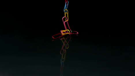 Paperclips-falling-on-black-background