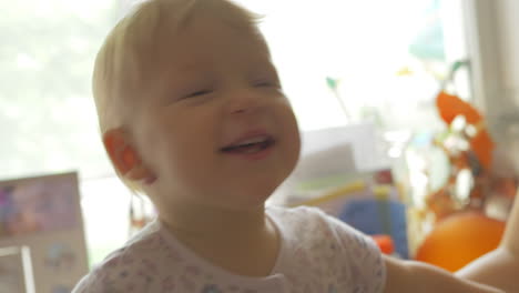 brother giving his baby sister a kiss at home