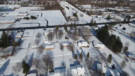 a slowly moving forward snowy aerial flyover of a suburban michigan residential neighborhood on a sunny winter day