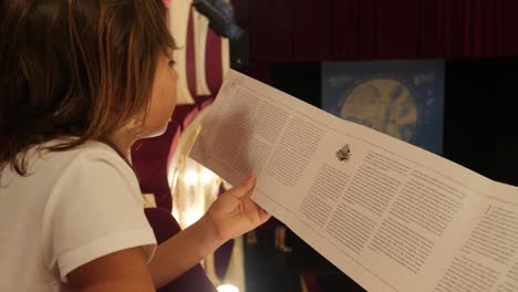 A-young-girl-reads-a-pamphlet-in-a-museum