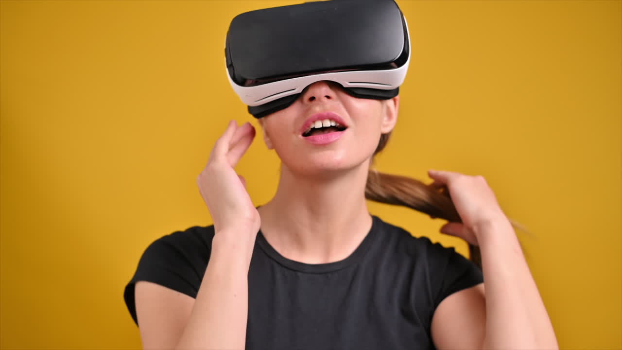 A young woman is excited while wearing VR glasses. Slow motion