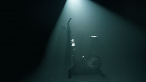 profile shot of an empty stationary bike glowing in cinematic backlight within a smoky, dark studio. a woman steps from the shadows, mounts the bike, and starts her workout with focused energy
