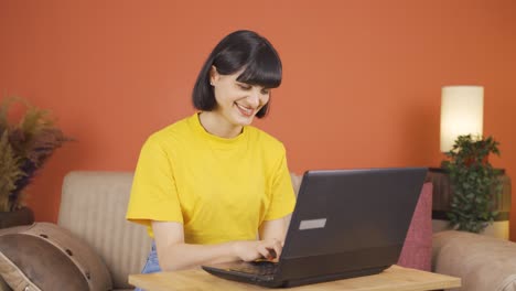 mujer trabajando en una computadora portátil con expresión feliz.